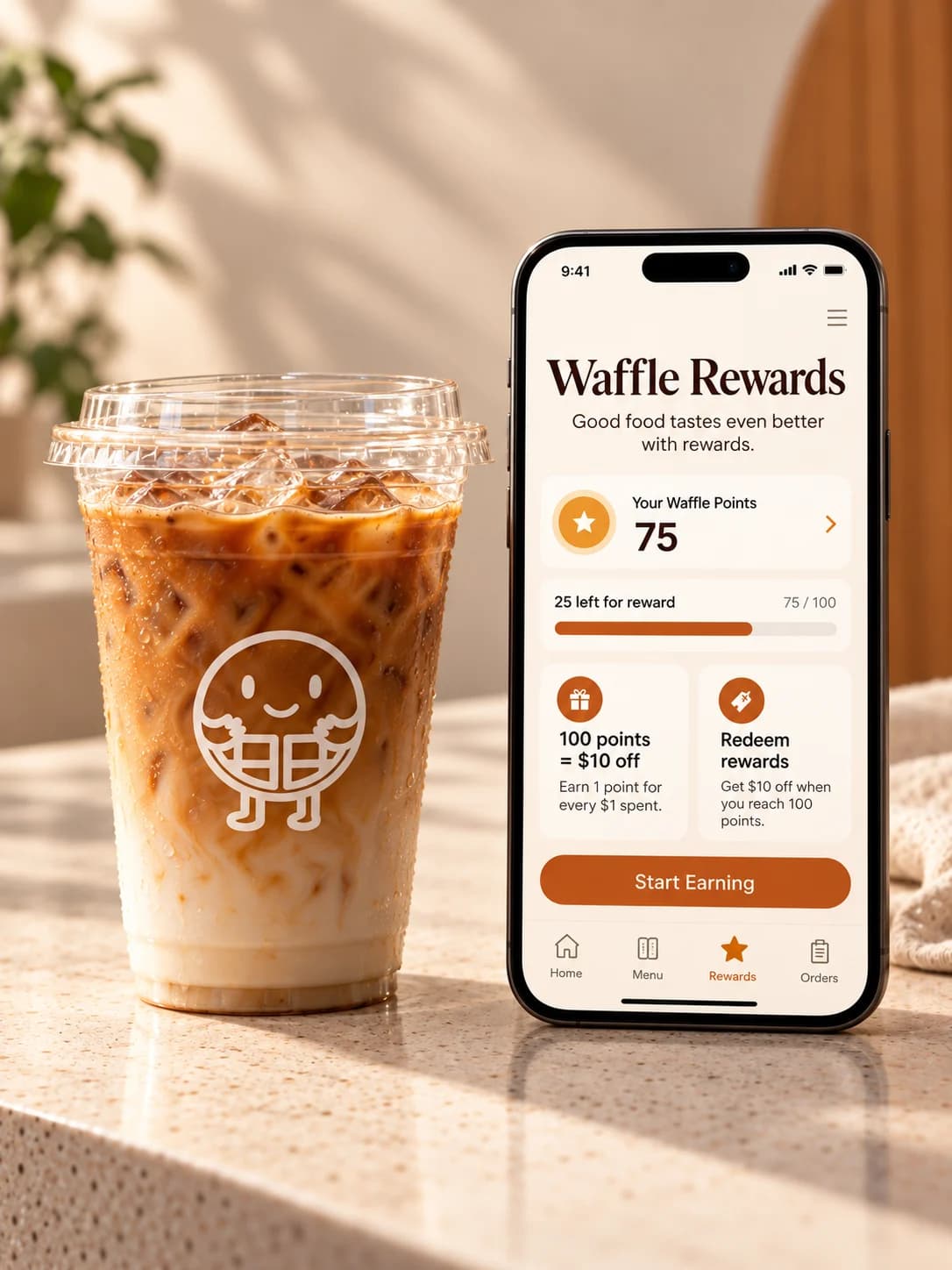 An iced coffee beside a phone showing the Waffle Rewards app with 75 of 100 points